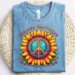 Blue shirt mockup of an image that says Choose Happiness over top of a sunflower with a peace symbol in the middle